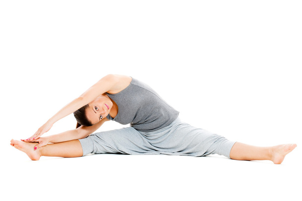Young woman doing stretch exercise on floor - Foto, Imagem