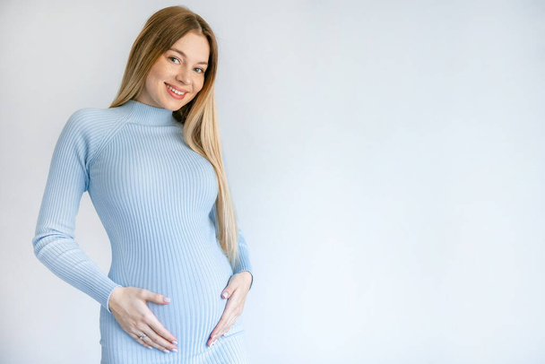 Young pregnant woman in blue dress on white background - Photo, Image