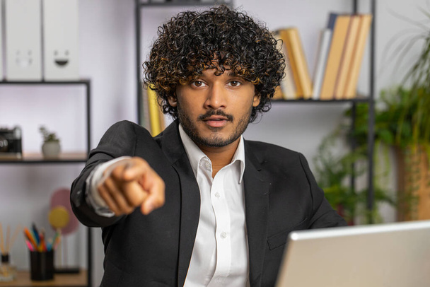 Eu escolho-te. Desenvolvedor de software de programador de empresário indiano jovem trabalhando no laptop do escritório apontando para a câmera, olhando com expressão feliz, fazendo escolha, mostrando a direção. Freelancer árabe homem - Foto, Imagem