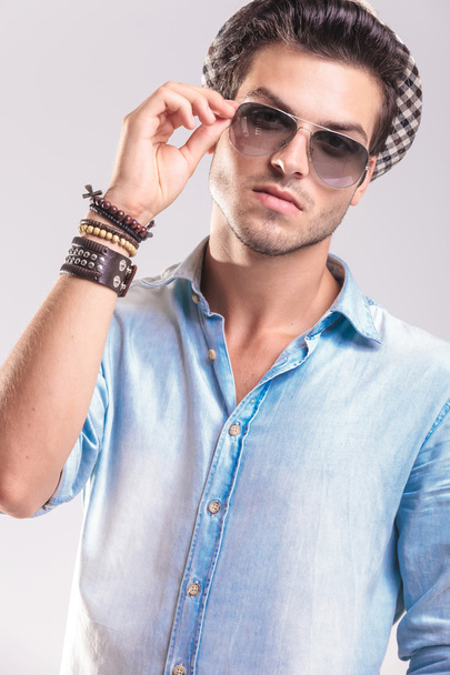 lässiger Modemann nimmt seine Sonnenbrille ab - Foto, Bild