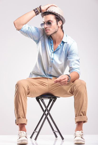Attractive fashion man sitting on a stool  - Фото, зображення