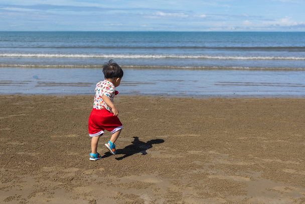 Boldog kisfiú szórakozás és futás a strandon - Fotó, kép