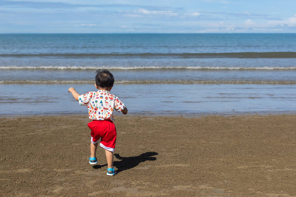 Boldog kisfiú szórakozás és futás a strandon - Fotó, kép