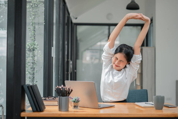 Business nainen rentouttava kädet pään takana ja istuu työtuoli - Valokuva, kuva