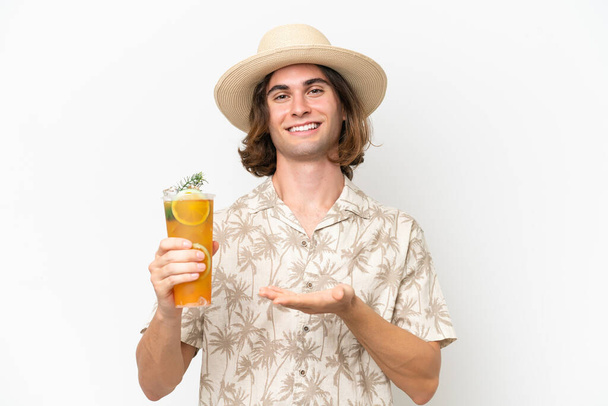 Giovane bell'uomo che tiene un cocktail isolato su sfondo bianco tendendo le mani di lato per invitare a venire - Foto, immagini