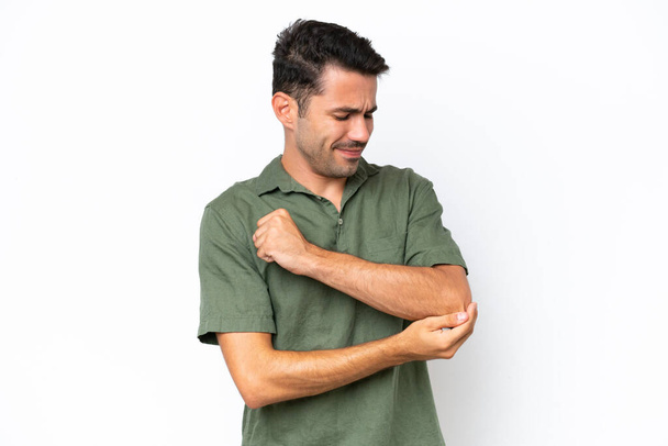 Νεαρός όμορφος άντρας πάνω από απομονωμένο λευκό φόντο με πόνο στον αγκώνα - Φωτογραφία, εικόνα
