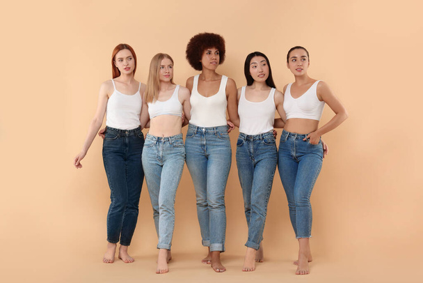 Group of beautiful young women on beige background - Foto, imagen