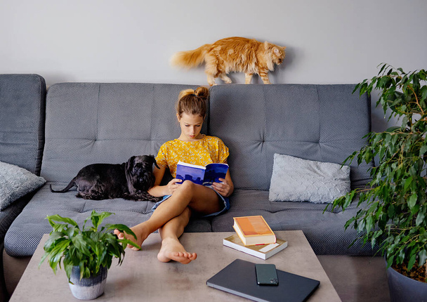 ψηφιακή αποτοξίνωση και ψυχαγωγική έννοια. κορίτσι ανάγνωση βιβλίο στο σπίτι - Φωτογραφία, εικόνα