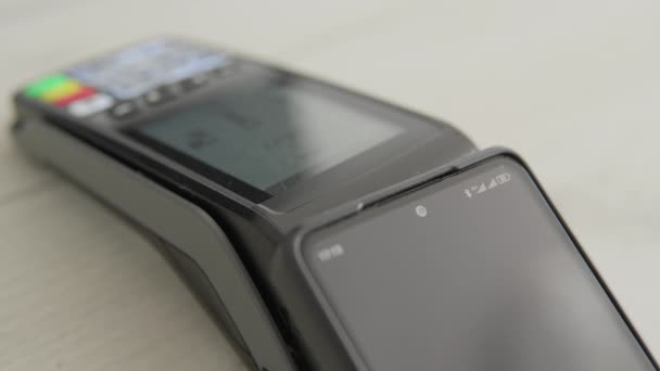 La tecnología NFC hace que el pago sea simple y rápido. Vea cómo pagar con su teléfono inteligente a través de un terminal POS. Pago sin contacto por teléfono, a través de una billetera electrónica. Banca electrónica. Alta calidad 4k - Metraje, vídeo