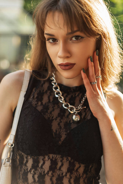 Modelo de mujer hipster bonita urbana en top de encaje de moda negra con bolsa al aire libre - Foto, imagen