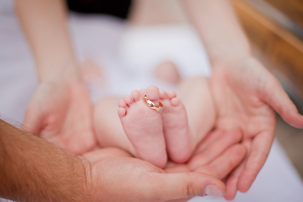 Κρατώντας το πόδι του νεογέννητου τους γονείς - Φωτογραφία, εικόνα