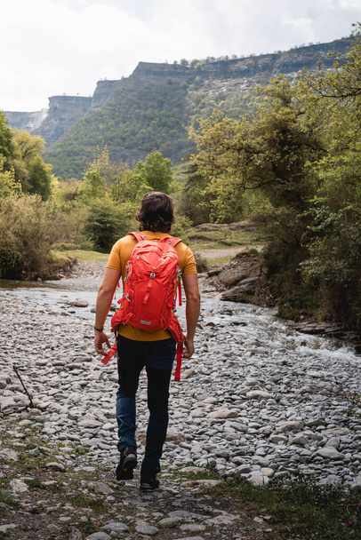Young mountaineer man, trekking in the Delika canyon, Alava, near the source of the Nervio waterfall - 写真・画像