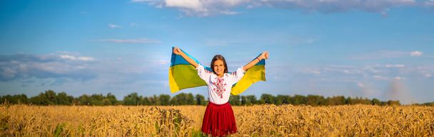 Παιδί σε χωράφι με σιτάρι με τη σημαία της Ουκρανίας. Επιλεκτική εστίαση. Παιδί. - Φωτογραφία, εικόνα