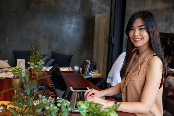 молода жінка використовує ноутбук, що працює онлайн в ресторані - Фото, зображення