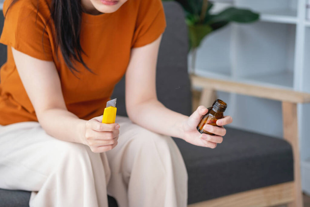 junge Frau sitzt mit vielen Tabletten auf dem Sofa Depressive Frau will sich durch Medikamentenüberdosis umbringen, Depressionskonzept - Foto, Bild