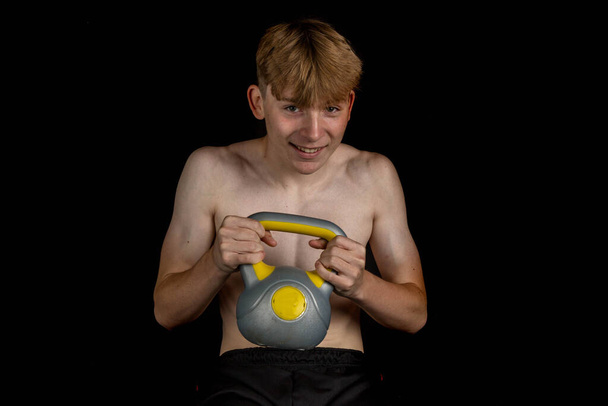Portrait of a sporty shirtless teenage boy doing Russian Twists - Zdjęcie, obraz