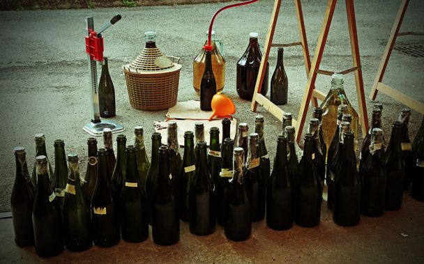 palackozás vörös bor az üveg palackok egy narancssárga tölcsér - Fotó, kép
