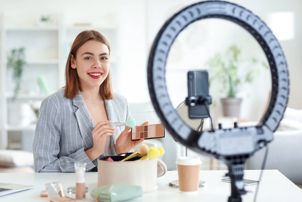 Female beauty blogger with eyeshadows recording video at home - Fotoğraf, Görsel