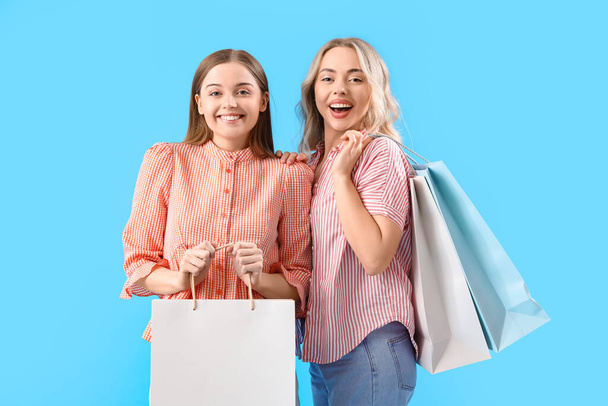 青の背景にショッピングバッグと妹 - 写真・画像