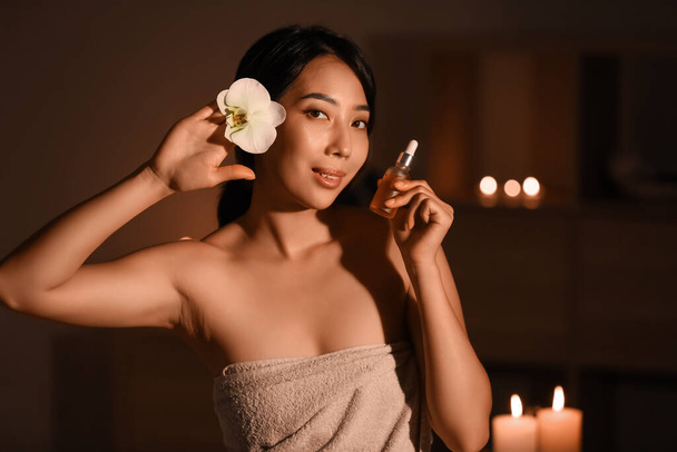 Mulher asiática muito jovem com óleo essencial no salão de spa - Foto, Imagem
