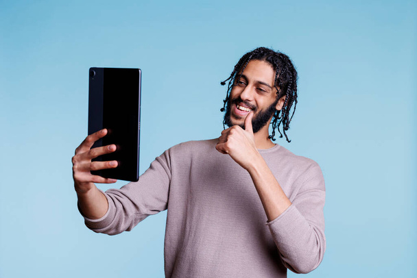 Glimlachende Arabische man die duim omhoog laat zien tijdens online ontmoeting op digitale tablet. Vrolijke persoon praten in videogesprek terwijl het maken van goedkeuring gebaar, met communicatie in videoconferentie - Foto, afbeelding