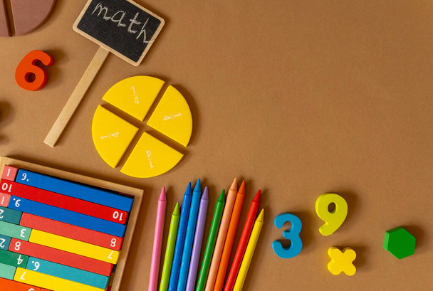 Красочные математические дроби, числа, буквы на коричневом фоне. Интересная, веселая, творческая математика для детей. Образование, вернемся к школьной концепции. Математический фон - Фото, изображение