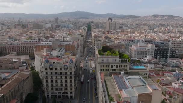 Voorwaarts vliegen boven Via Laietana straat omgeven door rijen van meerdere verdiepingen tellende historische huizen. Barcelona, Spanje. - Video