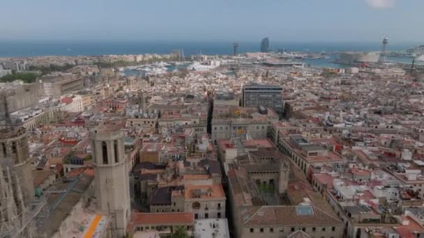 Voorwaarts vliegen boven de oude stad met kerken, en aantrekkelijke toeristische bezienswaardigheden. Jachten in de jachthaven aan zee kust op de achtergrond. Barcelona, Spanje. - Video