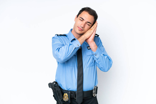 Nuori poliisi valkoisella taustalla eristetty valkoihoinen mies tekee unihelettä dorable ilme - Valokuva, kuva