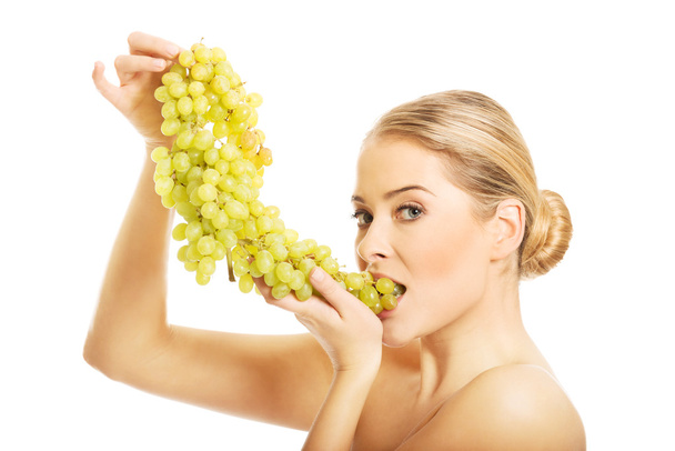 Nude woman eating grapes - Фото, изображение