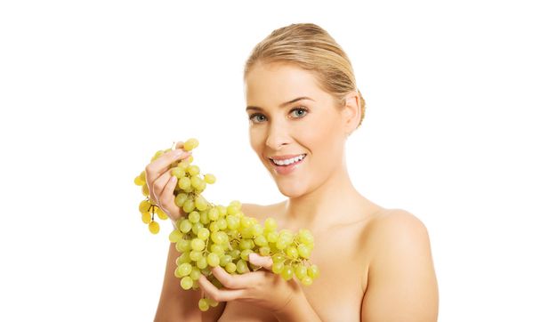 Nude woman eating grapes - Foto, imagen
