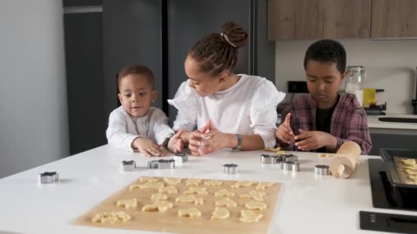 African family cutting cookie shapes in a cookie dough in the kitchen. Horizontal extended family. - Imágenes, Vídeo