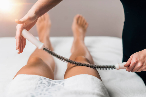 Massaggiare la coscia con il perno rotolante in una sala massaggi - Foto, immagini