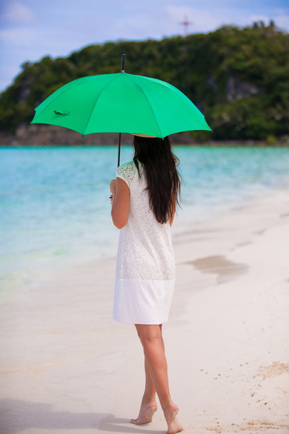 Young girl with umbrella on white beach - Photo, Image