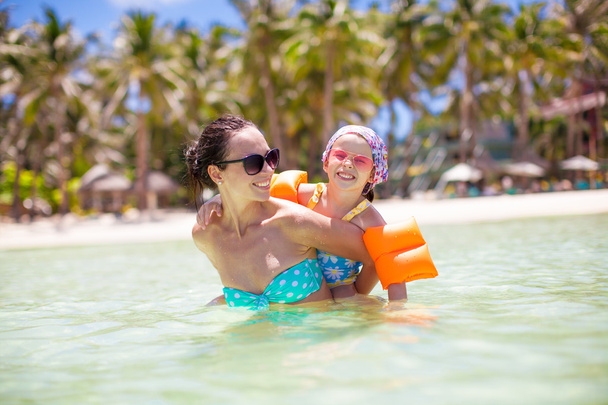 愛らしい少女と熱帯のビーチでの休暇中に幸せママ - 写真・画像