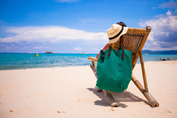 Jovem na praia cadeira de madeira durante as férias de verão
 - Foto, Imagem