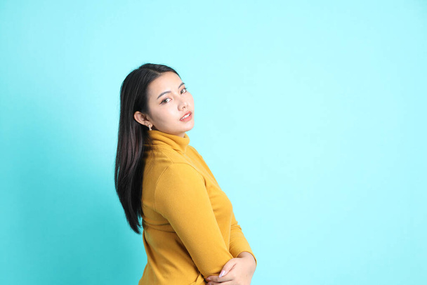 Aasialainen nainen rento vaatteita seisoo vihreällä taustalla. - Valokuva, kuva