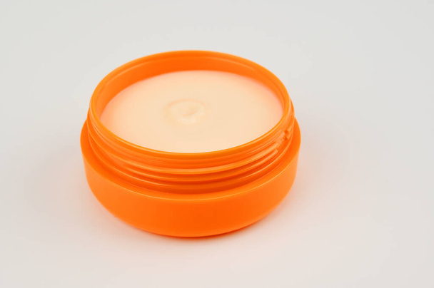 Crema de marfil en un recipiente redondo naranja - Foto, imagen