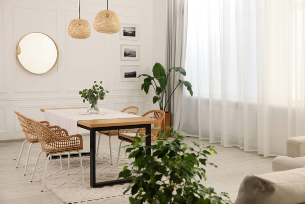 Stylish dining room with cozy furniture, mirror and plants - Zdjęcie, obraz