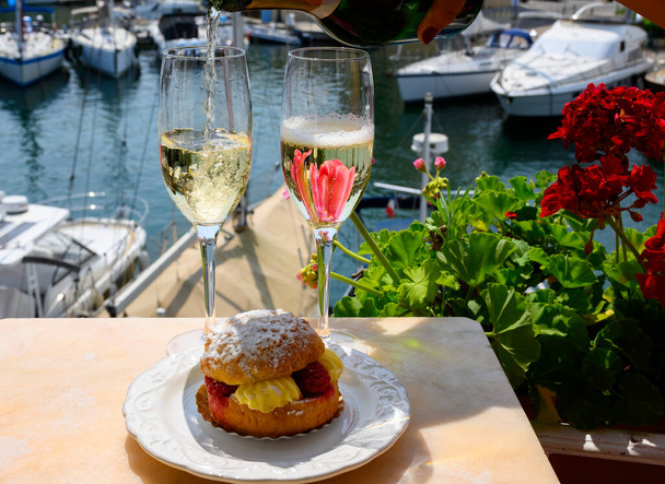 Beber vinho espumante de champanhe francês Brut com bolo Tarte Tropezienne, festa de clube no porto de iate de Port Grimaud perto de Saint-Tropez, férias na Riviera Francesa, Var, França - Foto, Imagem