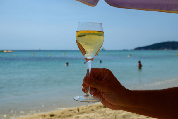 Kesäaika Provence, lasi kylmää valkoviiniä Pampelonne hiekkarannalla lähellä Saint-Tropez aurinkoisena päivänä, Var osasto, Ranska. - Valokuva, kuva