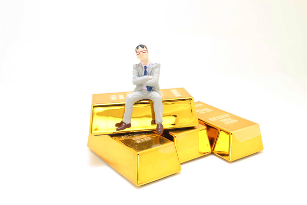 mini de Figura hombre de negocios sentado en la barra de oro - Foto, imagen