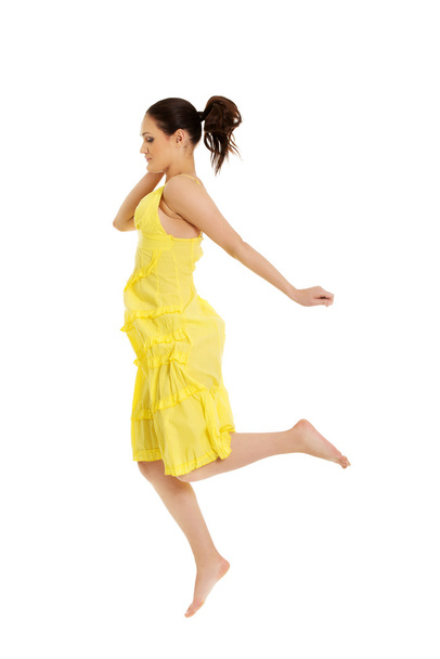 Beautiful woman jumping in yellow dress. - Foto, Imagen
