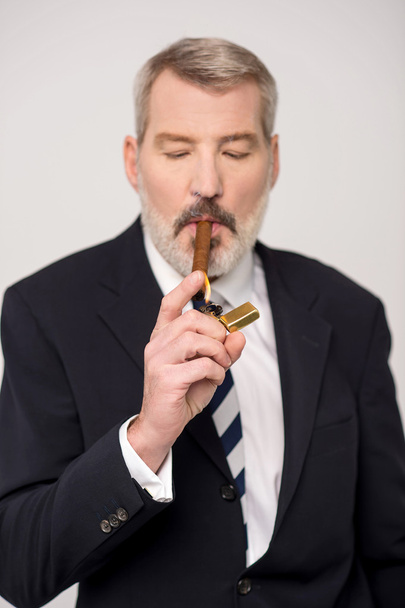 Businessman lighting up a cigar - Photo, image