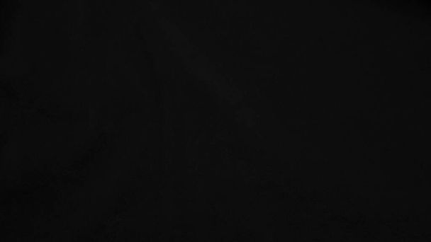 Тёмно-чёрная бархатная ткань используется в качестве фона. черный цвет панне ткань фона из мягкого и гладкого текстильного материала. crusvelvet .luxury - ночной тон для шелка - Фото, изображение