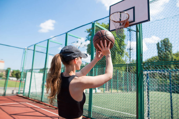 Athletic female basketball player throwing a ball up to the net. - Photo, Image