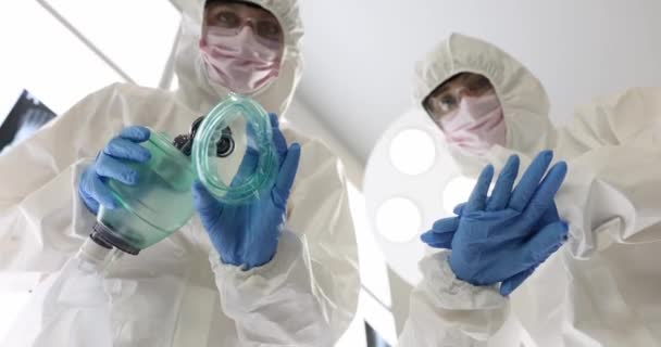 Αναισθησιολόγος με προστατευτική στολή σκύβει πάνω σε ασθενή που κρατάει μάσκα προσώπου με στρογγυλό σχήμα αναισθησίας. Χειρουργός προετοιμάζει άρρωστο άτομο για χειρουργική επέμβαση αργή κίνηση - Πλάνα, βίντεο