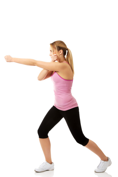 Young woman in kick fitness pose. - Zdjęcie, obraz