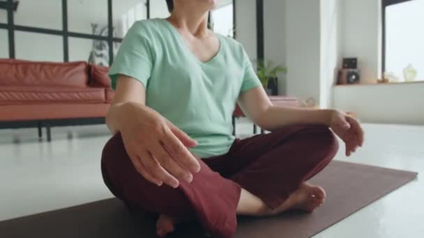 Yaşlı kadın evde yoga egzersizi yapıyor. Olgun kadınlar meditasyon yapar. Yüksek kalite 4k görüntü - Video, Çekim