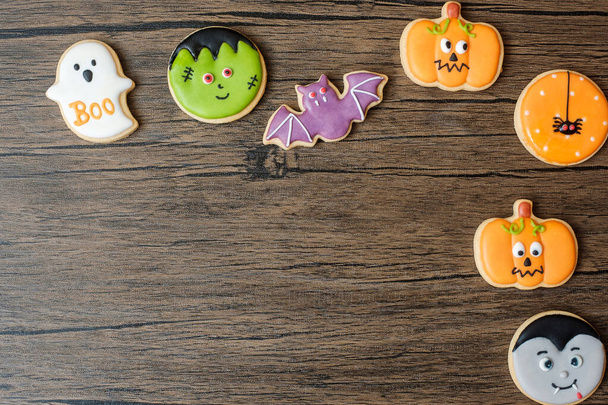 Ahşap masa arkasında komik kurabiyelerle Cadılar Bayramı 'nız kutlu olsun. Trick or Threat, Hello October, güz, şenlik, parti ve tatil konsepti - Fotoğraf, Görsel